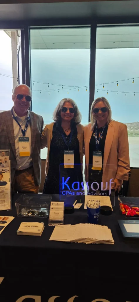 Kassouf team members stand with promotional materials at their booth.
